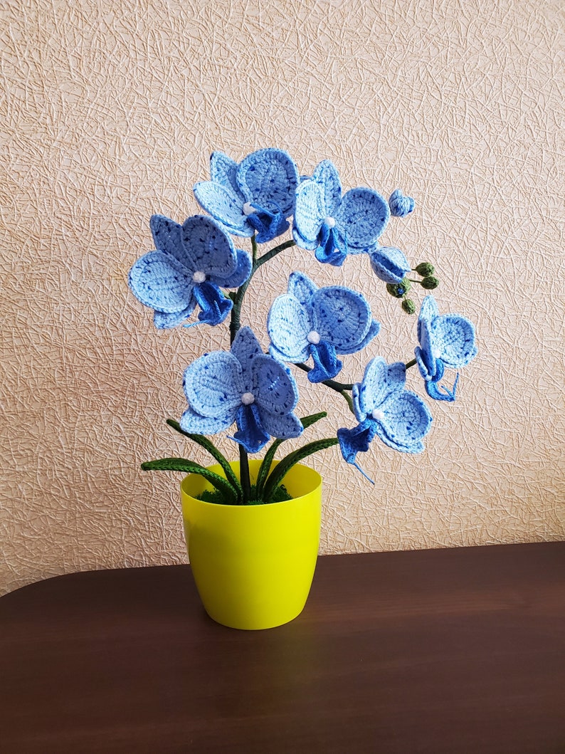 Gehaakte orchideeplant in gele pot, blauw bloemdecor van acrylgaren
