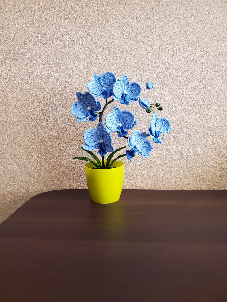 Gehaakte orchideeplant in gele pot, blauw bloemdecor van acrylgaren