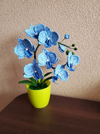 Gehaakte orchideeplant in gele pot, blauw bloemdecor van acrylgaren