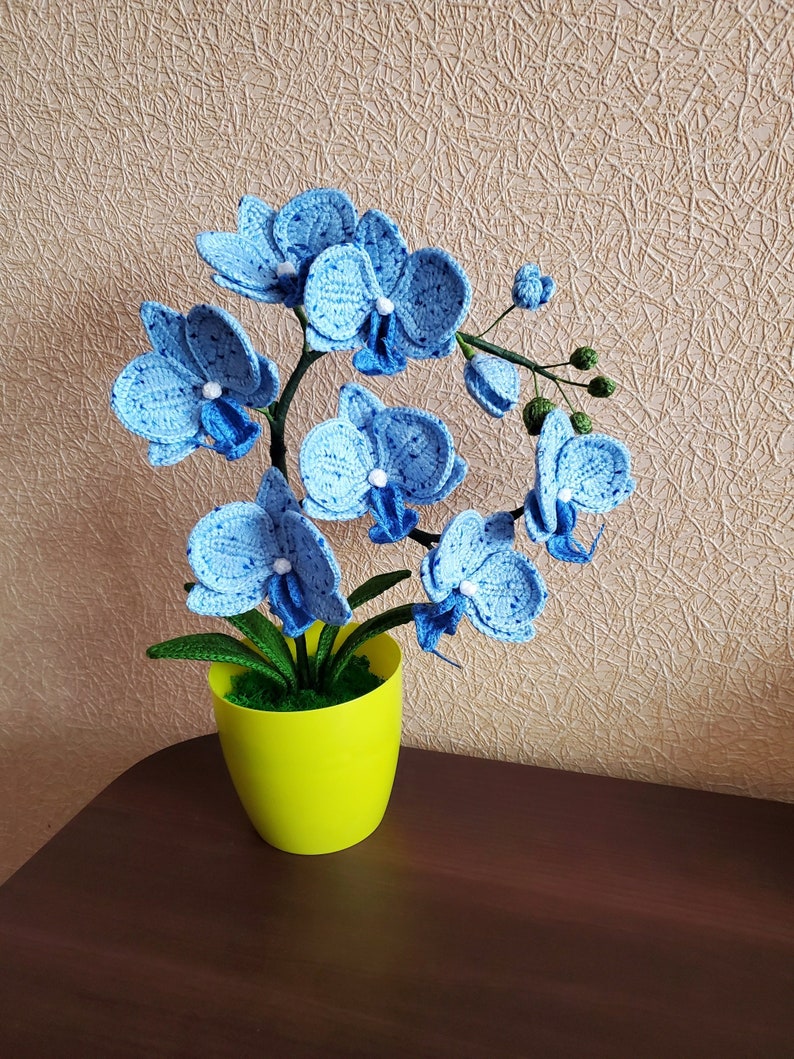 Gehaakte orchideeplant in gele pot, blauw bloemdecor van acrylgaren
