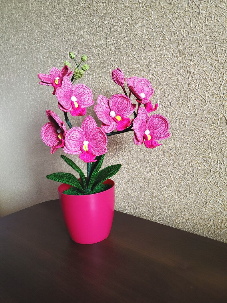 Gehaakt bloemdecor roze orchidee met gebogen stelen en groene bladeren in pot