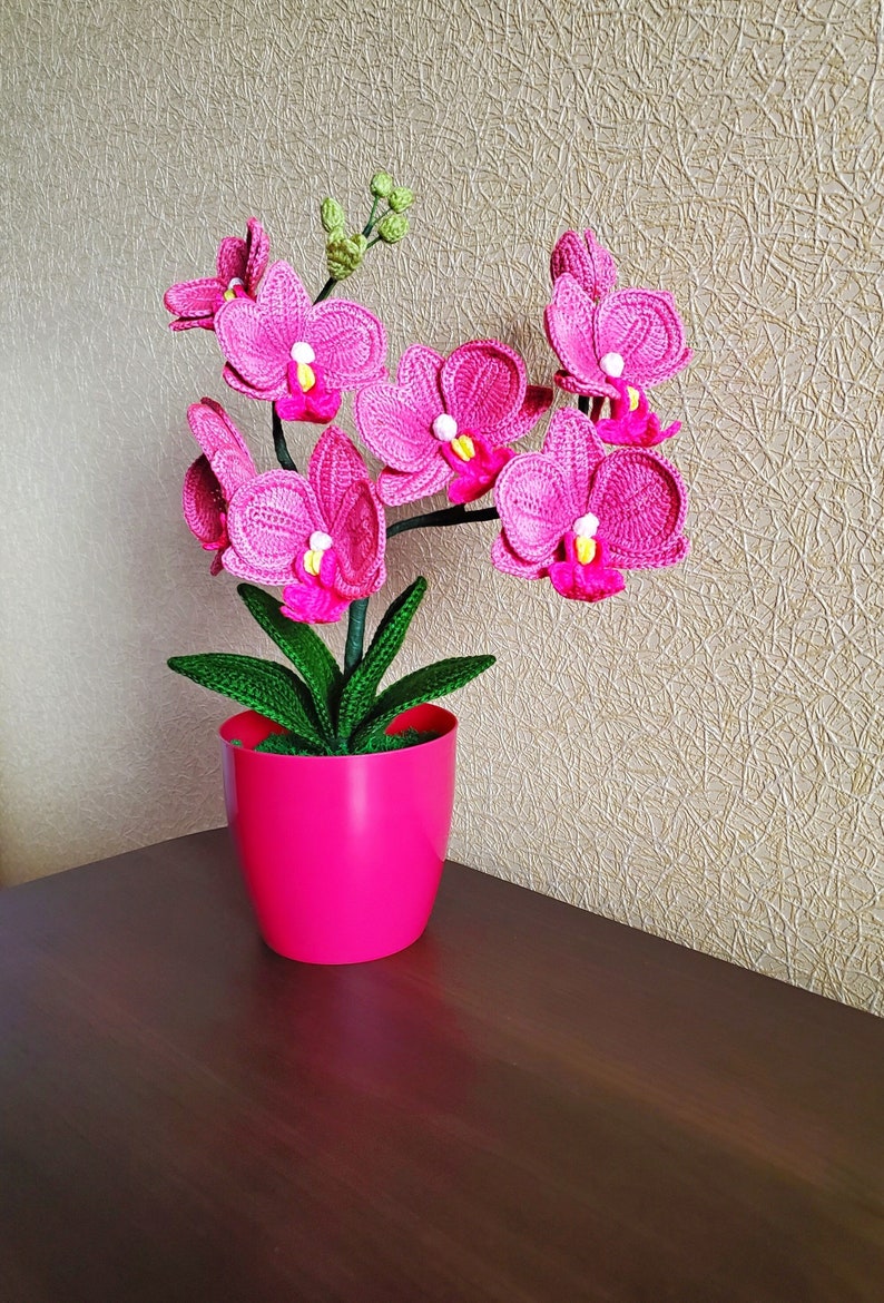Gehaakt bloemdecor roze orchidee met gebogen stelen en groene bladeren in pot