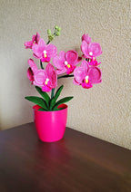 Gehaakt bloemdecor roze orchidee met gebogen stelen en groene bladeren in pot