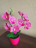 Gehaakt bloemdecor roze orchidee met gebogen stelen en groene bladeren in pot