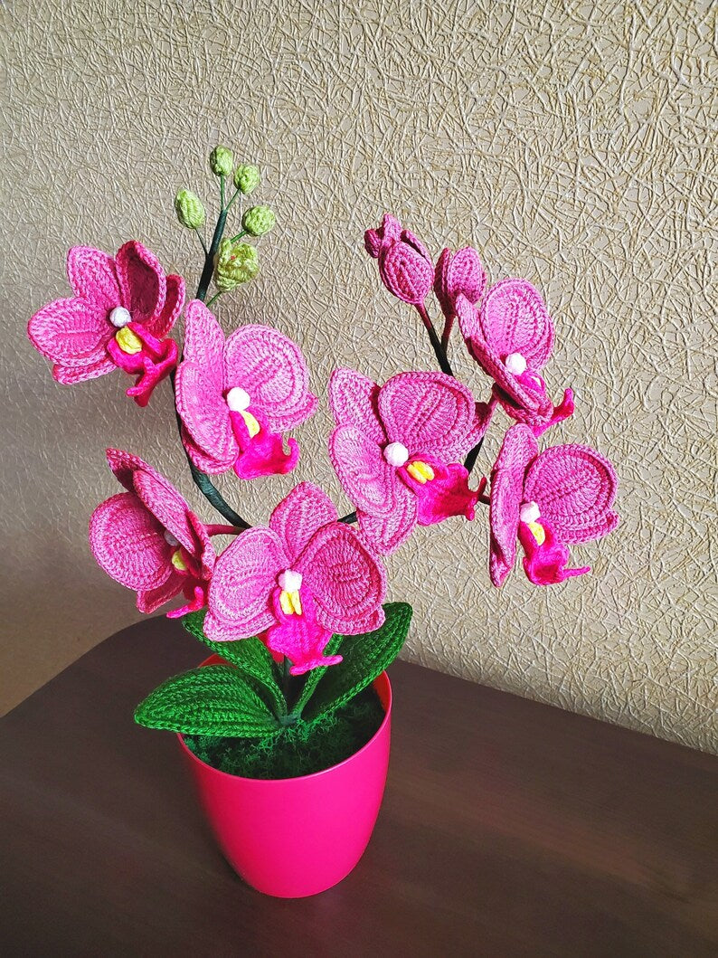 Gehaakt bloemdecor roze orchidee met gebogen stelen en groene bladeren in pot