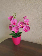 Gehaakt bloemdecor roze orchidee met gebogen stelen en groene bladeren in pot