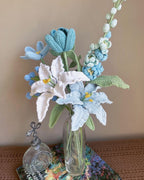Gehaakt bloemboeket met blauwe lelie, tulp en roos in vaas