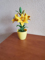 Gehaakte lelieplant in gele pot, handgemaakt botanisch decor met goudgele bloemen