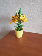 Gehaakte lelieplant in gele pot, handgemaakt botanisch decor met goudgele bloemen