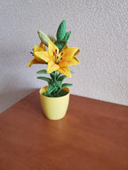Gehaakte lelieplant in gele pot, handgemaakt botanisch decor met goudgele bloemen