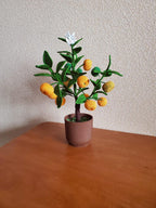 Gehaakte mandarijnboom met gelaagde bladeren en witte bloesem voor plankdecoratie