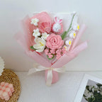 Handgehaakt bloemboeket met konijnenknuffel en garenbloemen in zachtroze papier