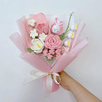 Handgehaakt bloemboeket met konijnenknuffel en garenbloemen in zachtroze papier
