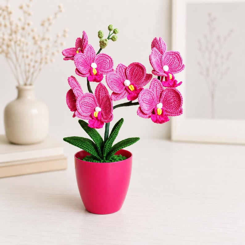 Gehaakt bloemdecor roze orchidee met gebogen stelen en groene bladeren in pot