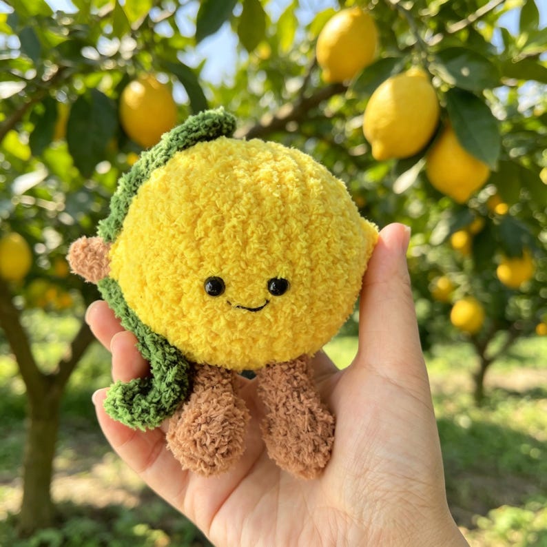 Handgemaakte gehaakte fruitknuffel van pluche chenillegaren met lachend gezichtje en kleine beentjes