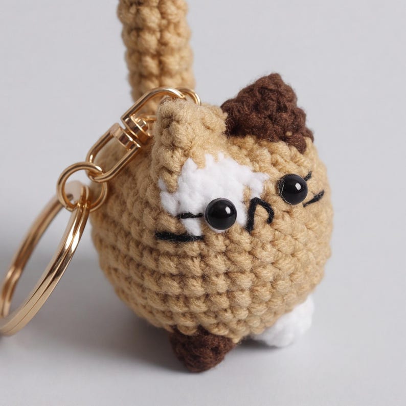 Gehaakte kattensleutelhanger met lapjeskatontwerp en opstaande staart