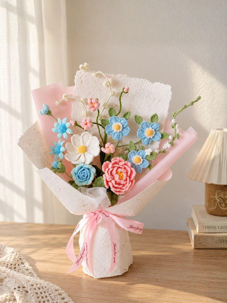 Pastelkleurig gehaakt bloemenboeket met blauwe en roze rozen en madeliefjes