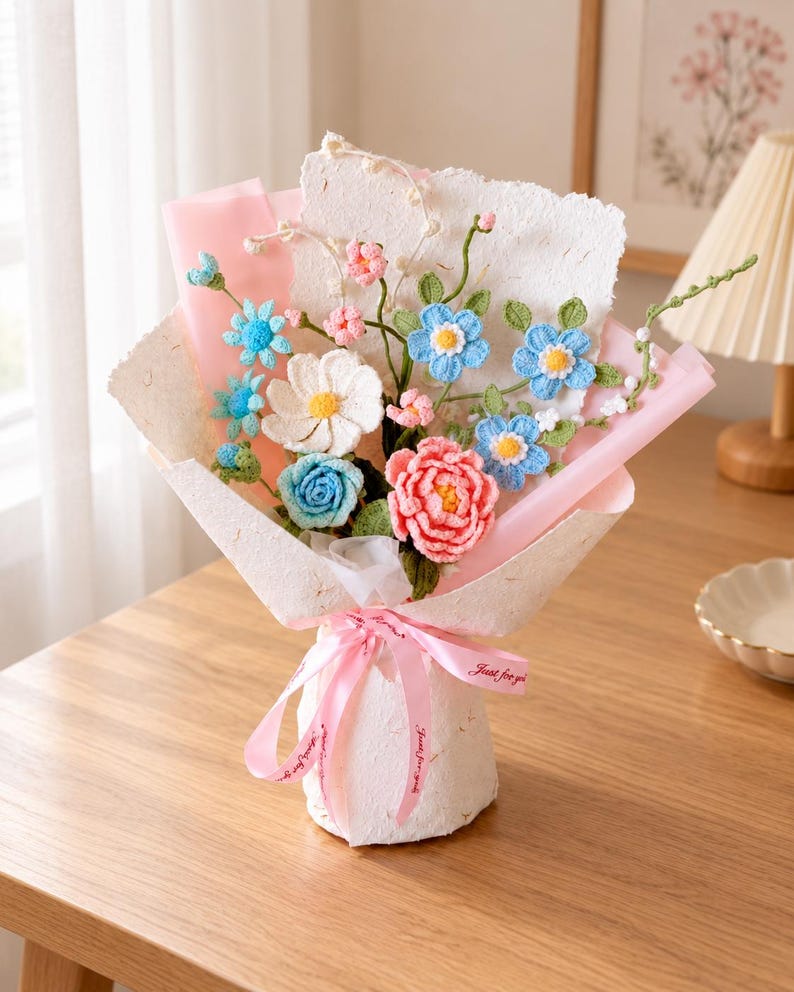 Pastelkleurig gehaakt bloemenboeket met blauwe en roze rozen en madeliefjes