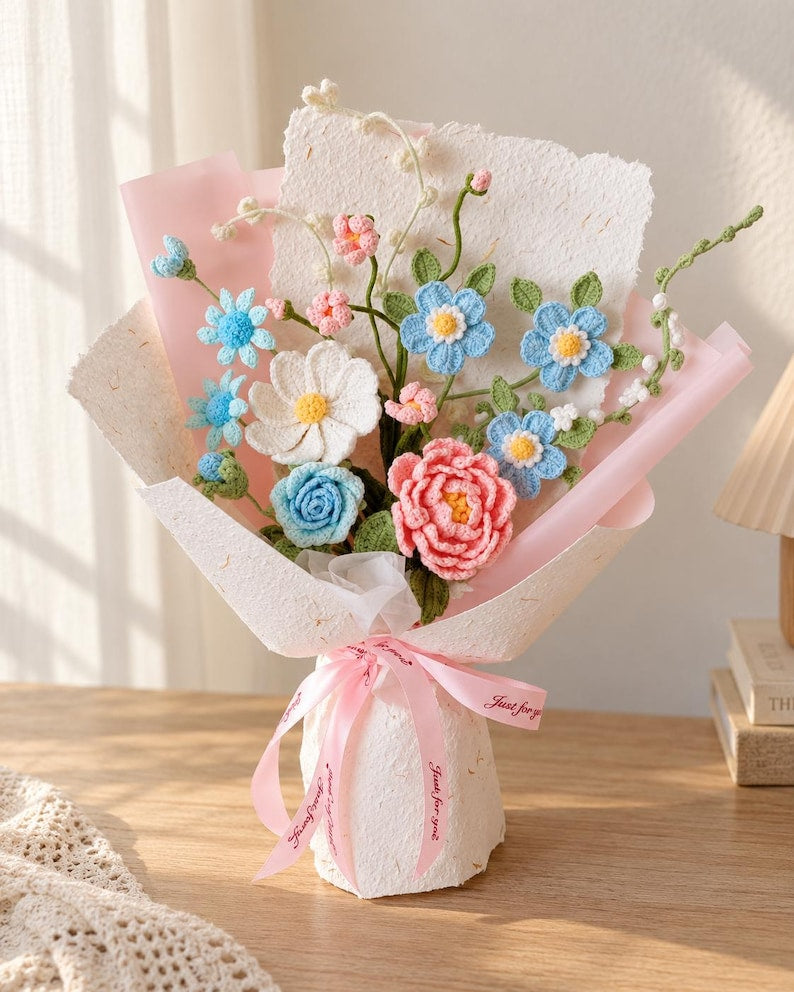 Pastelkleurig gehaakt bloemenboeket met blauwe en roze rozen en madeliefjes